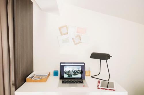 a desk with a laptop and a lamp on it at La Suite aquitaine in Bordeaux