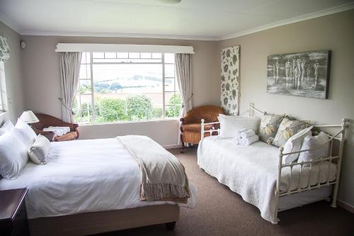 a bedroom with two beds and a window at Sangwana 27 Holiday Home in Underberg