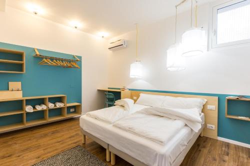 ein Schlafzimmer mit einem Bett und einer blauen Wand in der Unterkunft Casa Colibrì - Solemar Sicilia in Santa Flavia