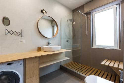 a bathroom with a sink and a washing machine at Casa Colibrì - Solemar Sicilia in Santa Flavia