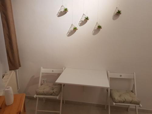a white table and two chairs in a room at Valentin ház in Szentendre