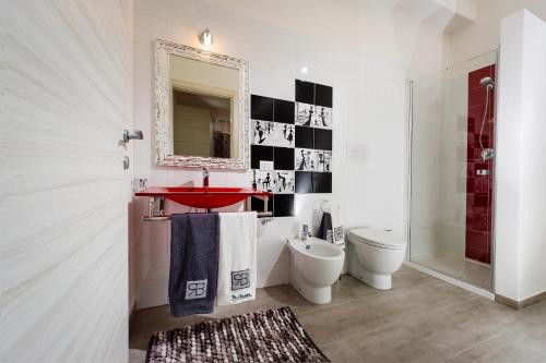 a bathroom with a sink and a toilet and a mirror at Cineholiday House 1 in Castellammare del Golfo
