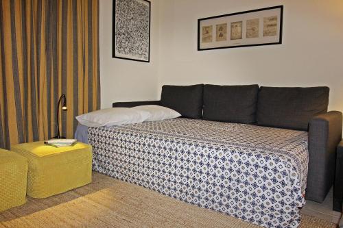 a bedroom with a bed with a blanket on it at Bombarda House & Home in Porto