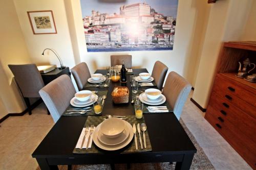 a dining room table with a black table and chairs at Bombarda House & Home in Porto