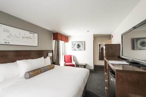 une chambre d'hôtel avec un lit et une télévision dans l'établissement Edgewater Hotel, à Whitehorse