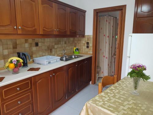 a kitchen with wooden cabinets and a table and a refrigerator at Georgia Old Town Apartments in Rhodes Town