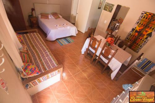 Habitación con cama, mesa y sillas. en Cabañas Eterno Vergel en Mburucuyá
