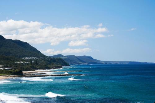 a view of the ocean with waves hitting the shore at Headlands Austinmer Beach in Austinmer