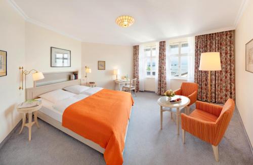 ein Hotelzimmer mit einem Bett, einem Tisch und Stühlen in der Unterkunft Hotel Bad Schachen in Lindau