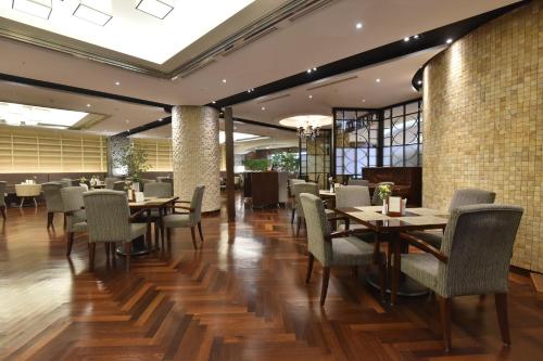 un restaurante con suelo de madera, mesas y sillas en Pacific Hotel, en Seúl