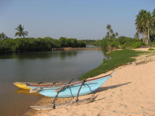 due barche sedute sulla riva di un fiume di Villa Sunrise a Tangalle