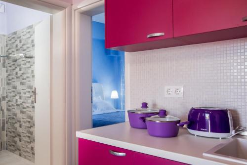 オルモス・パナギアスにあるOrmos View Apartmentsのキッチン(赤いキャビネット、紫色の電化製品付)
