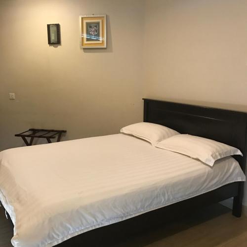 バターワースにあるSe One Hotelの部屋にある白いシーツと枕が置かれたベッド