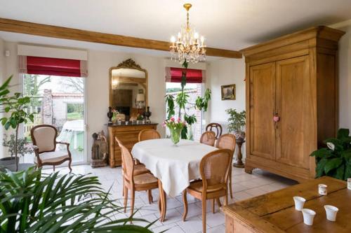 une salle à manger avec une table et des chaises blanches dans l'établissement Le Bout du Monde, à Berneville