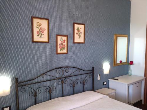 ヴィエステにあるB&B Villa Makkalèのベッドルーム1室(ベッド1台付)が備わります。壁に3枚の写真が飾られています。