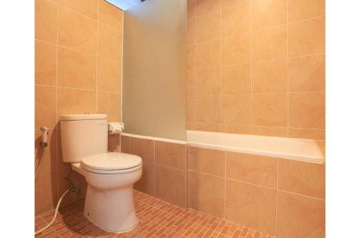 a bathroom with a toilet and a bath tub at Matahari Bungalow in Legian