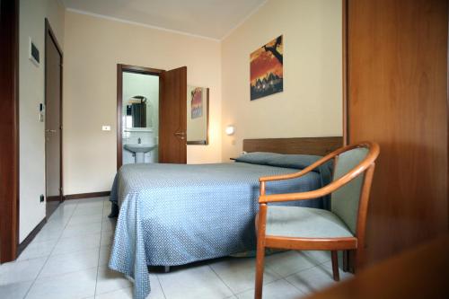 a bedroom with a bed and a chair and a sink at Hotel Cristal in Bari