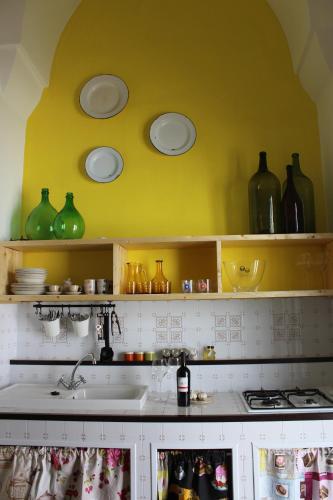 a kitchen with green glass vases on the wall at Villa Colittacarrafa in Galatone