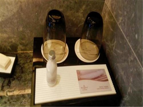 a table with two glasses and a bottle of soap at Pullman Yantai Center in Yantai