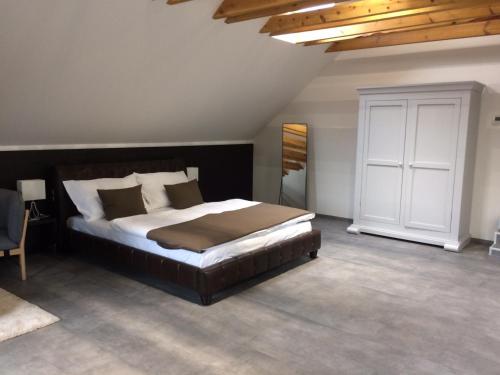 a bedroom with a large bed and a white cabinet at Hotel Panství Dlouhá Lhota in Dlouhá Lhota
