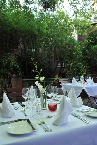 a table set with white tablecloths and napkins at Premier Hotel Quatermain in Johannesburg