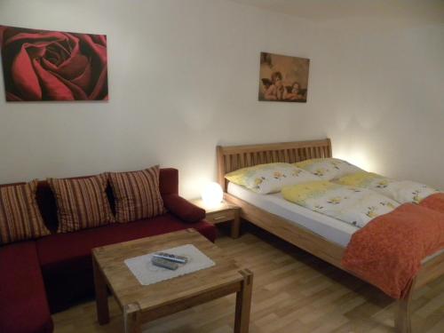 a small bedroom with a bed and a couch at Urlaub am Bauernhof Gänser in Sankt Peter am Kammersberg