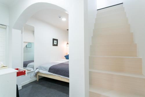 a bedroom with a bed and a staircase at Neat House in Seoul