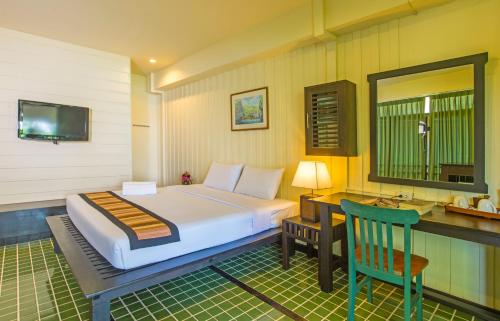 a bedroom with a bed and a desk and a mirror at Krabi City Seaview Hotel in Krabi