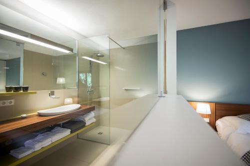 uma casa de banho com uma cabina de duche em vidro e um lavatório. em Designhotel Gius La Residenza em Caldaro