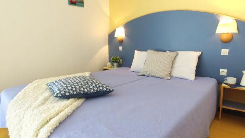 a blue bedroom with a large bed with pillows at VVF Méjannes Gard in Méjannes-le-Clap