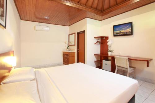 a hotel room with a bed and a desk at Matahari Bungalow in Legian