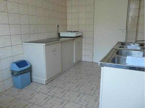 a kitchen with a sink and a trash can at Dom Studencki Atol in Krakow