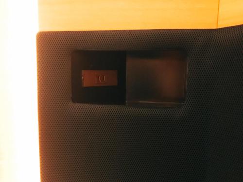 a black tiled wall with a clock on it at Sauna & Capsule Hotel Rumor Plaza in Kyoto
