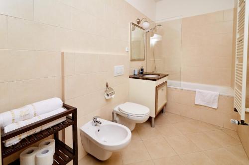 a bathroom with a toilet, sink, and bathtub at Three Golden Crowns Apartments in Prague