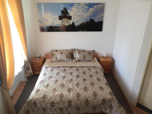 a bedroom with a bed and a picture on the wall at Apartment Una - Self check in in Graz