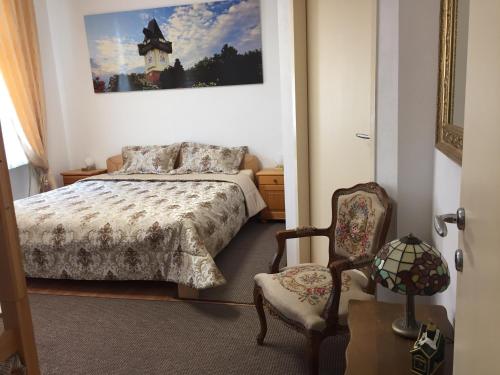 a bedroom with a bed and a chair at Apartment Una - Self check in in Graz