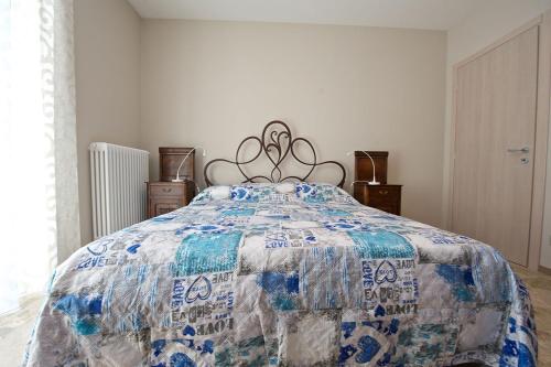 a bedroom with a bed with a blue and white quilt at Bella Vista Barbaresco in Barbaresco