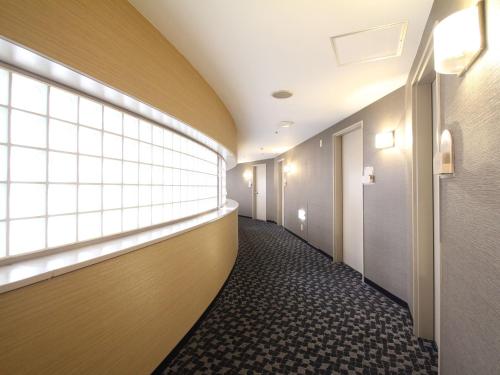 a corridor of a hospital hallway with a window at APA Hotel Fukuoka Watanabedori Ekimae EXCELLENT in Fukuoka