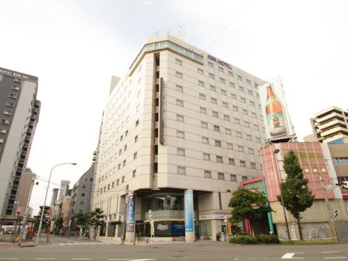 een groot wit gebouw in een stadsstraat bij APA Hotel Fukuoka Watanabe Dori EXCELLENT in Fukuoka