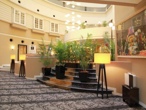a lobby with potted plants on the stairs at APA Hotel Fukuoka Watanabedori Ekimae EXCELLENT in Fukuoka