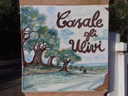 a sign for a house with trees on a road at Casale Gli Ulivi in Orbetello
