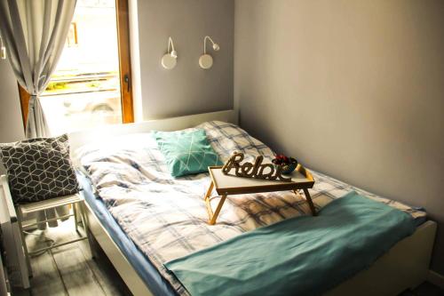 a small bedroom with a bed with a table on it at Apartament Justyna in Stegna