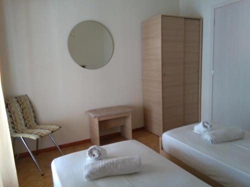 a room with two beds and a mirror and a chair at Olena House in Kavala