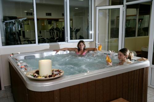 two girls in a bath tub with a candle at Venardos Hotel in Agia Pelagia Kythira