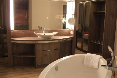 a bathroom with a bath tub and a sink at Flair Hotel Weiss in Angermünde