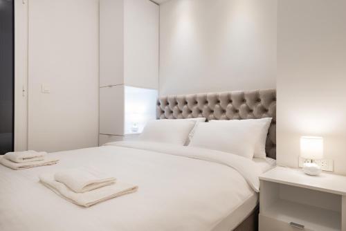 a bedroom with a white bed with towels on it at Vivio Luxury Apartment in Belgrade