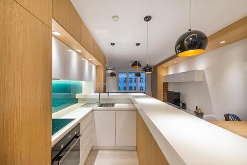 a kitchen with white cabinets and a counter top at Vivio Luxury Apartment in Belgrade