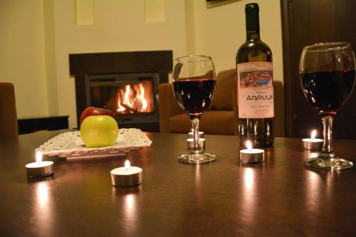 a bottle of wine and two glasses on a table at Thermios Apollon in Thermo