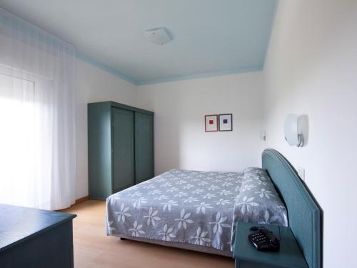 a bedroom with a bed and a dresser in it at Aparthotel La Pineta in Lido di Jesolo