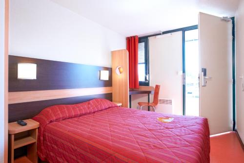 a bedroom with a bed with a red blanket at Premiere Classe Orleans Nord - Saran in Saran